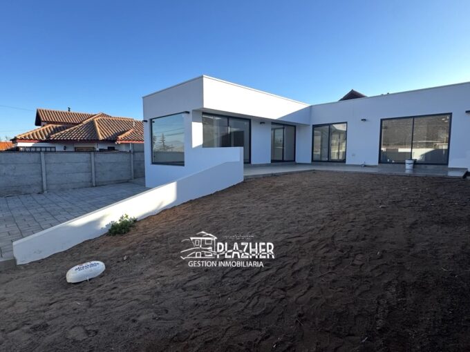Casa nueva de una planta, blanca y con grandes ventanales, en Barrio San Joaquín